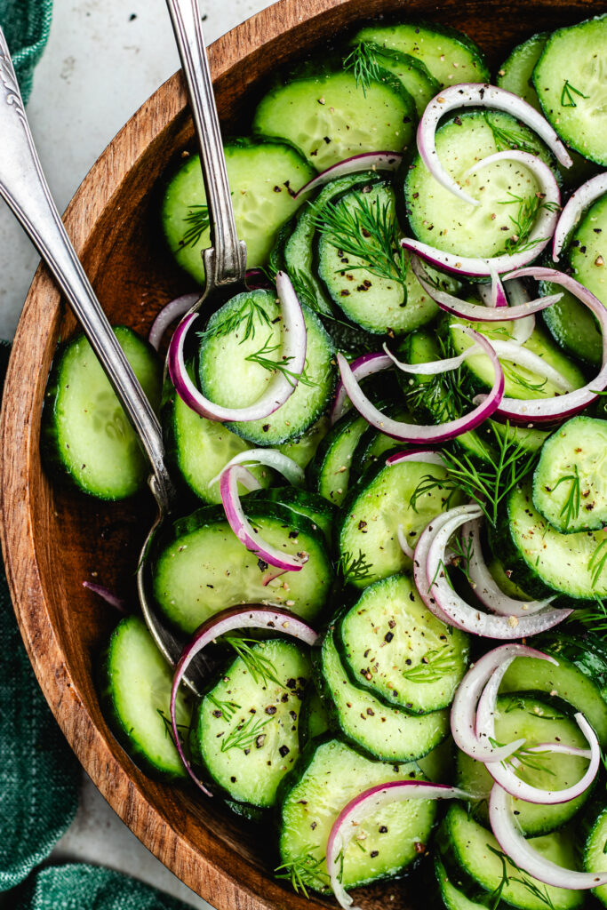 The salad topped with fresh dill in a wooden bowl.