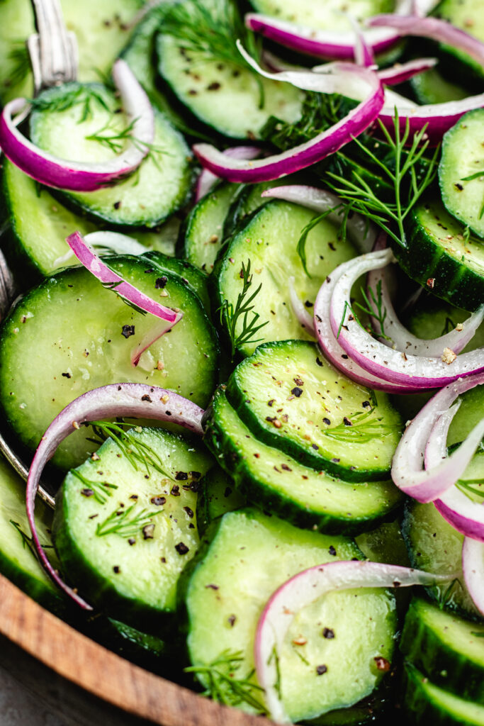 The salad topped with fresh dill in a wooden bowl.