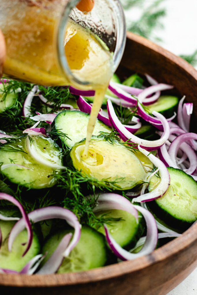 Pouring the dressing over the salad.