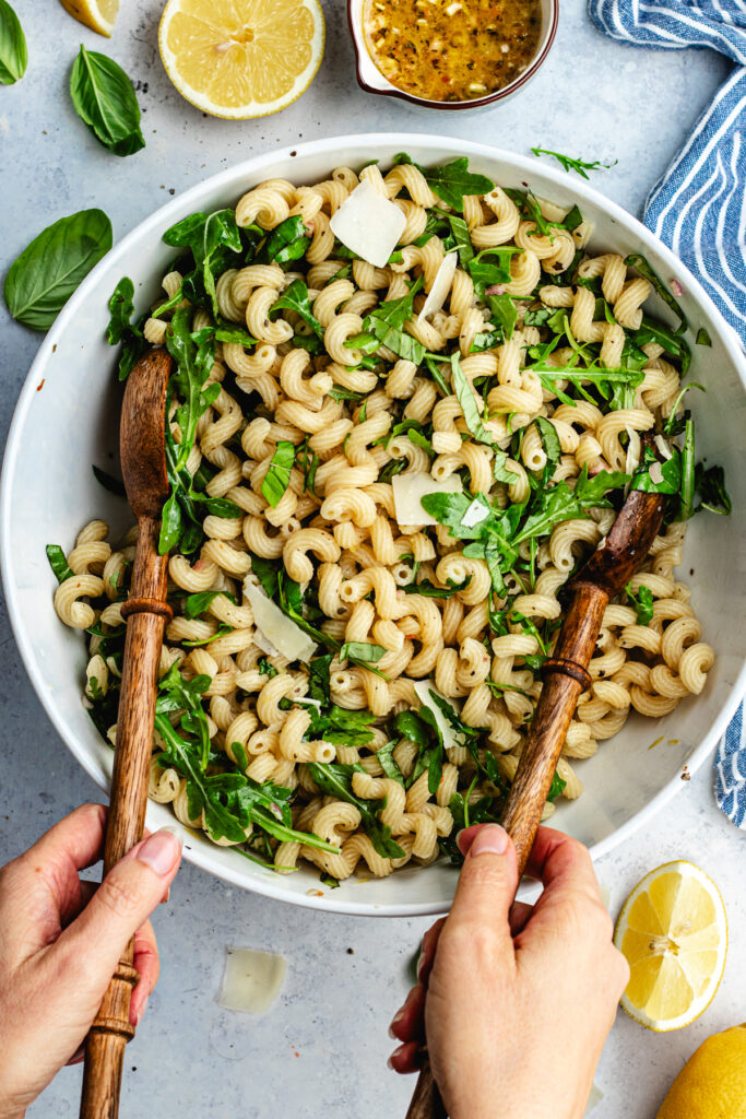 Tossing the salad together in the bowl.