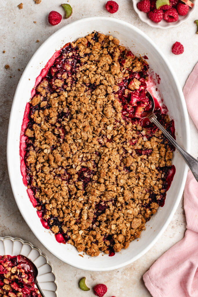 The baked crumble in the baking dish with a serving spoon. 