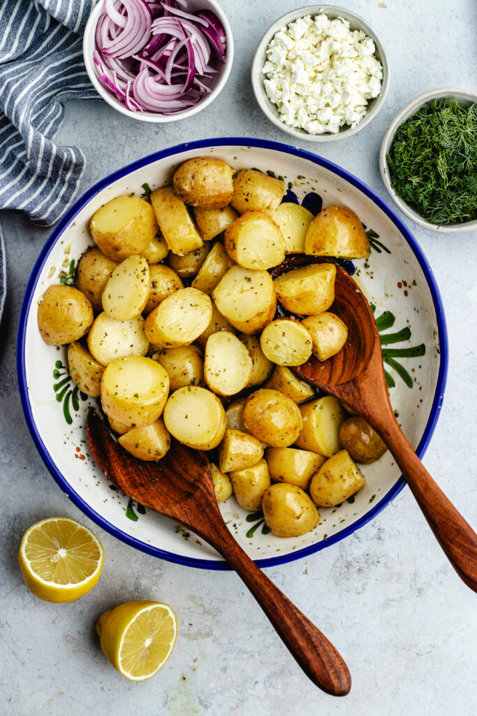 Tossing the potatoes with the dressing.