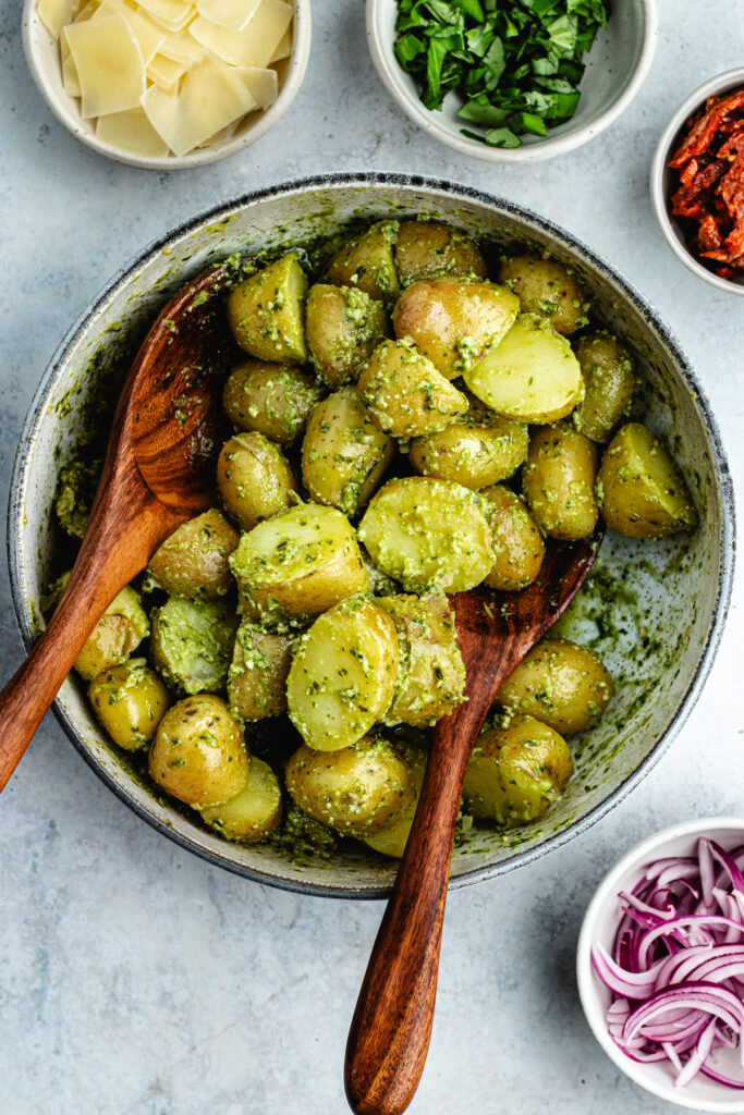 Tossing the potatoes with the pesto. 