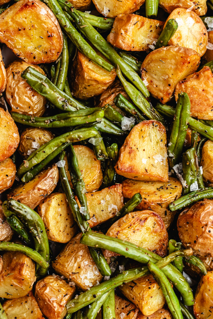 The roasted potatoes and green beans on a serving platter.