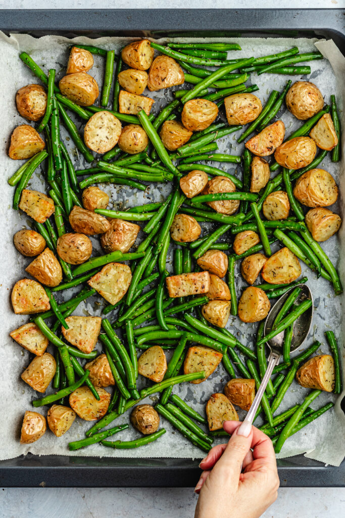 The added green beans to the baking sheet.