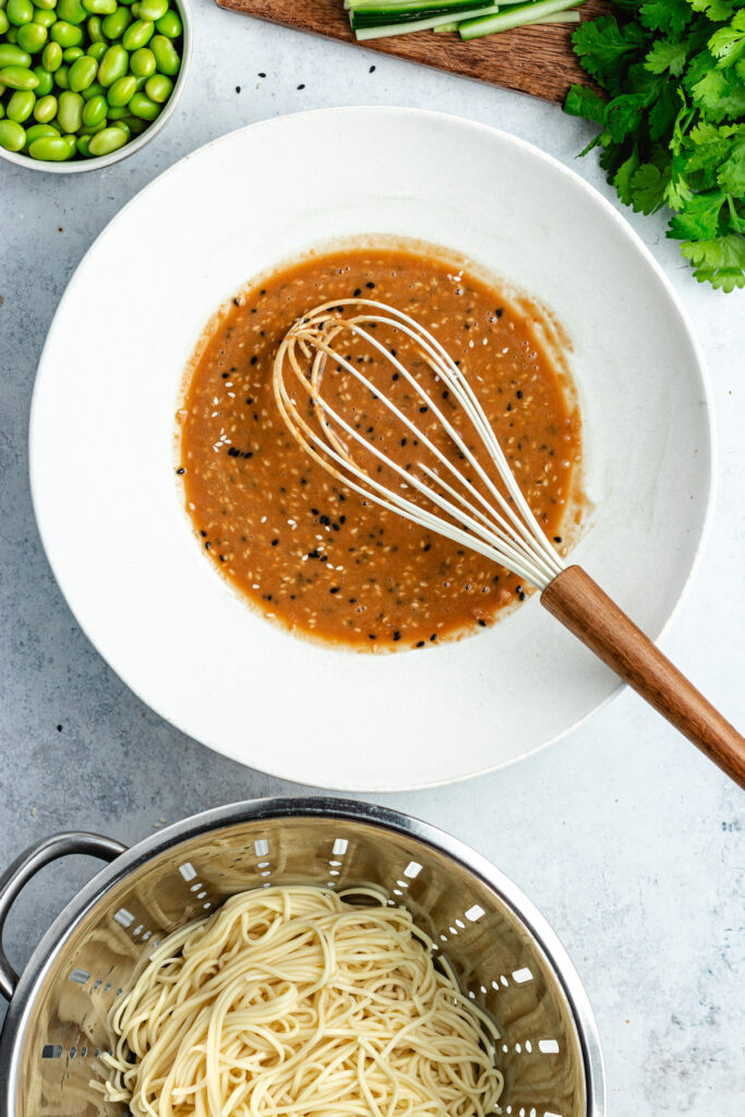 The mixed sauce in the bowl and the cooked noodles. 