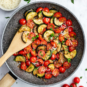 The finished dish in the frying pan topped with parmesan and parsley.