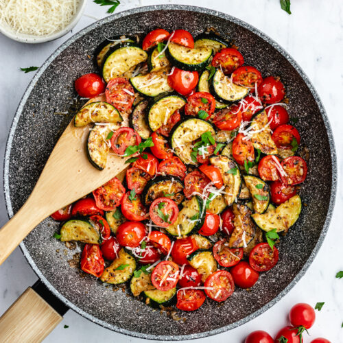 The finished dish in the frying pan topped with parmesan and parsley.