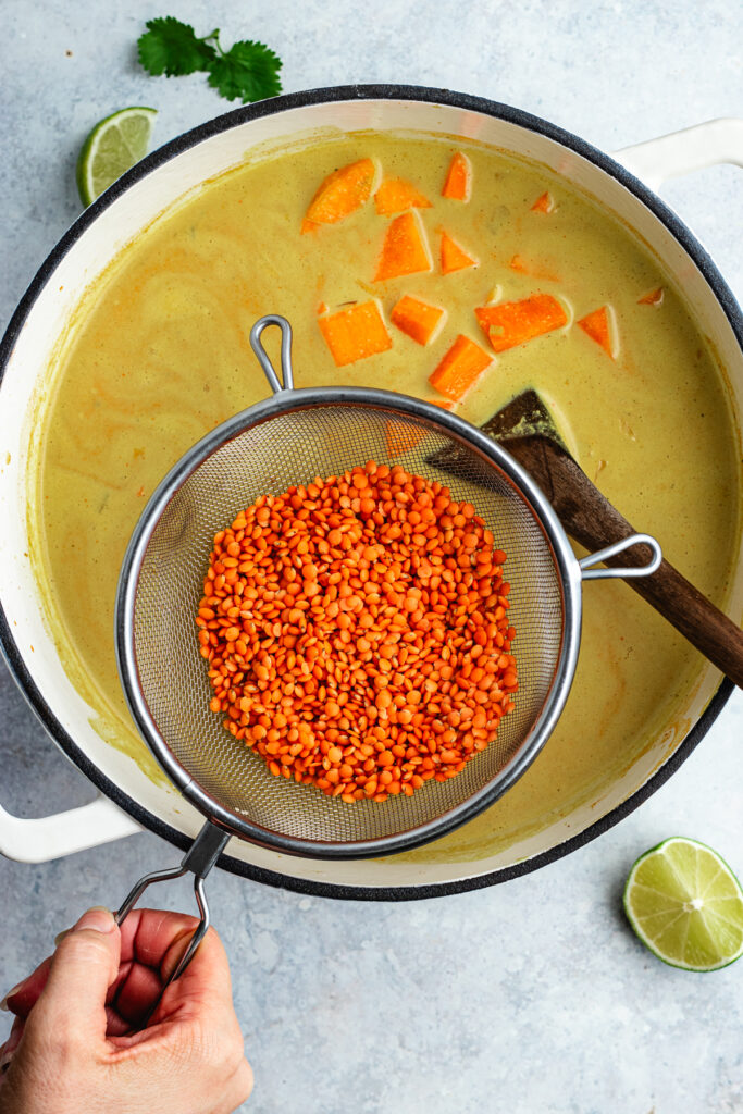 Adding the rinsed lentils to the soup.