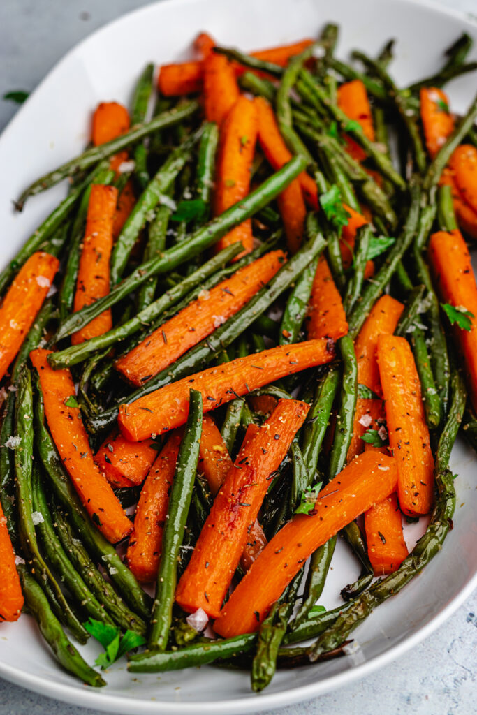 The roasted vegetables on a serving platter topped with chopped parsley.