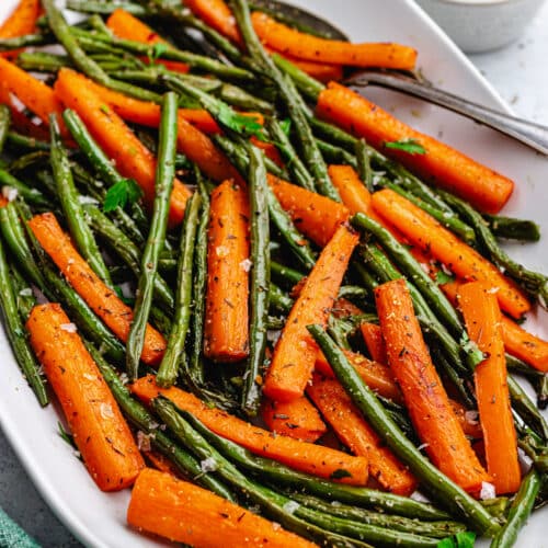 The roasted vegetables on a serving platter topped with chopped parsley.