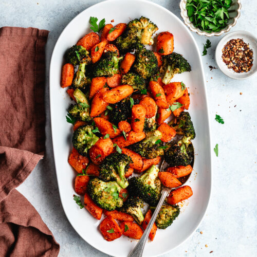The roasted veggies on a serving platter topped with chopped parsley.