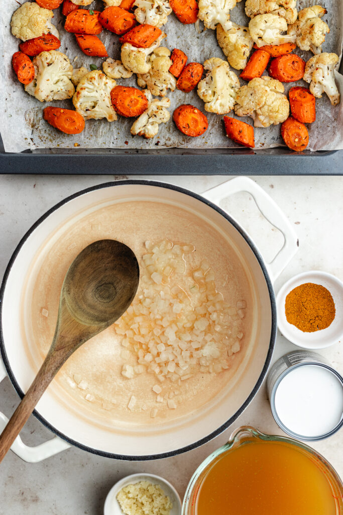 The sautéed onions in a soup pot.