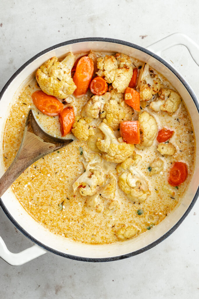 The added veggies, broth and coconut milk to the soup pot.