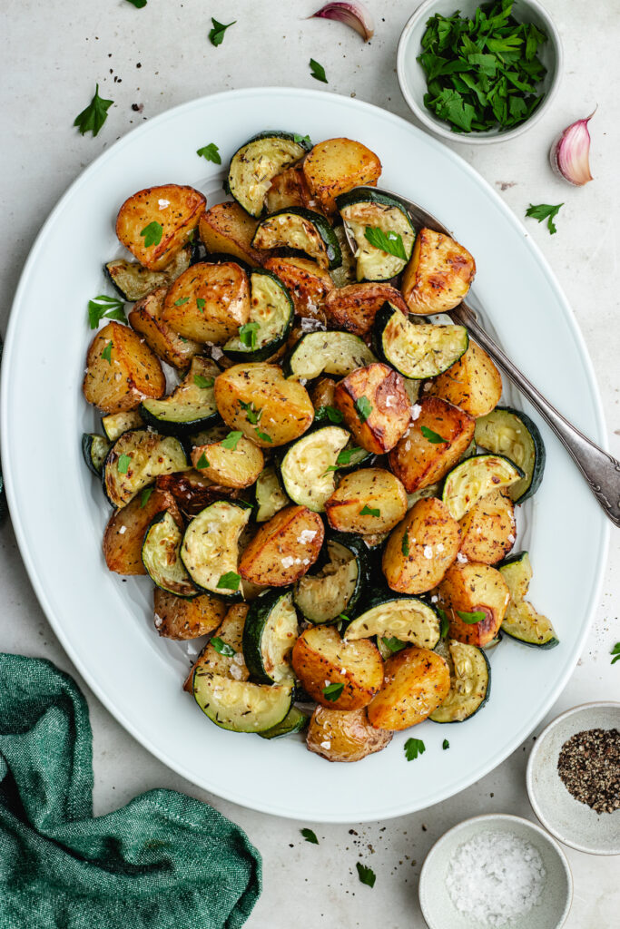 The roasted veggies on a serving platter topped with chopped parsley. 