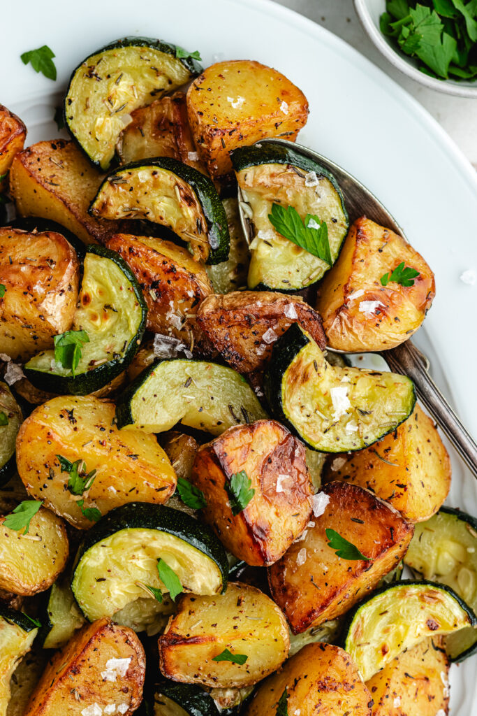 The roasted veggies on a serving platter topped with chopped parsley.