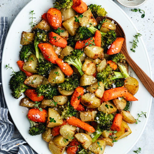 The roasted veggies on a serving platter topped with fresh thyme.