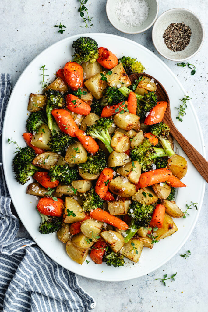 The roasted veggies on a serving platter topped with fresh thyme.