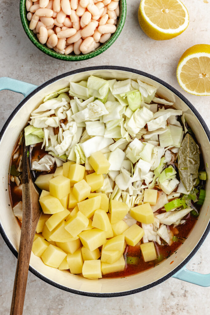 the cabbage and potatoes added to the soup pot with the canned tomatoes and vegetable broth.