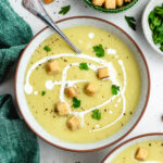 The soup topped with a drizzle of cream, croutons and fresh parsley.