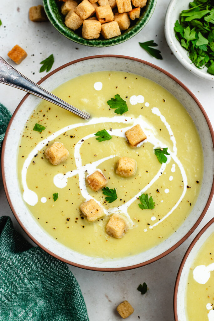The soup topped with a drizzle of cream, croutons and fresh parsley.