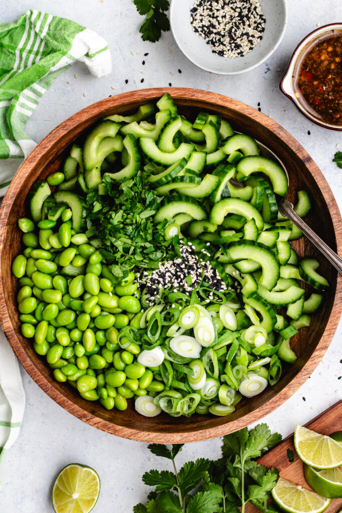 The vegetables, sesame seeds and herbs in a salad bowl.