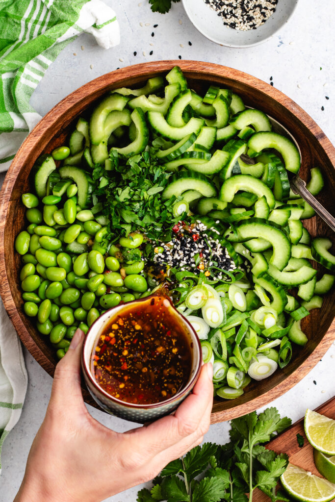 Pouring the dressing in the salad.