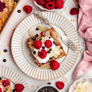 The raspberry baked oats cut into pries and plated with some yoghurt and fresh berries.