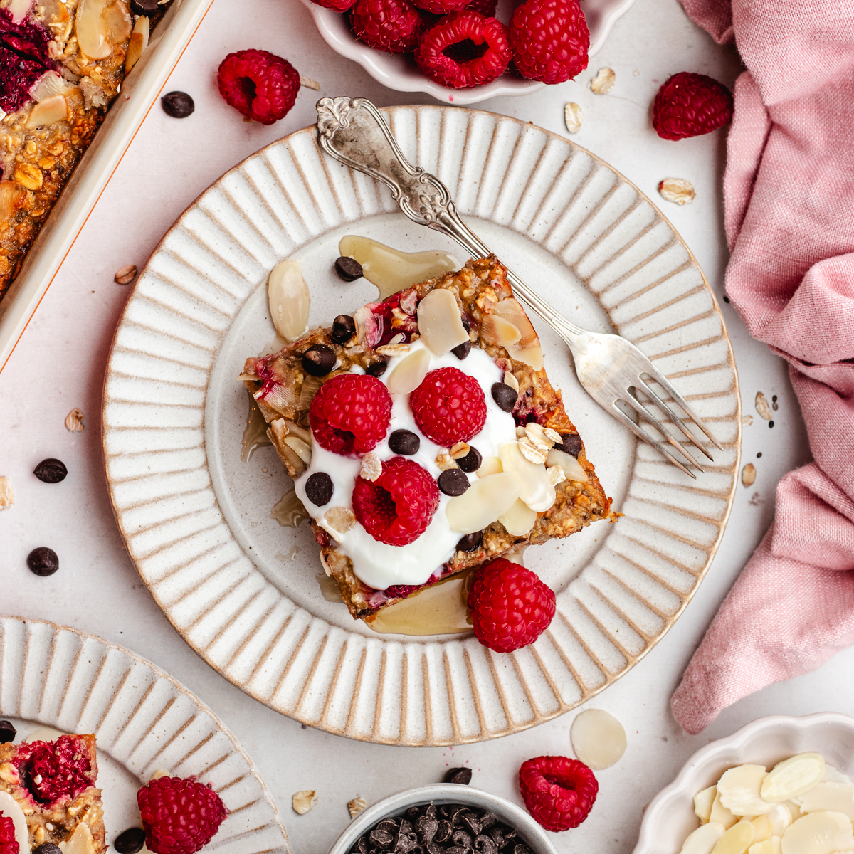 The raspberry baked oats cut into pries and plated with some yoghurt and fresh berries.