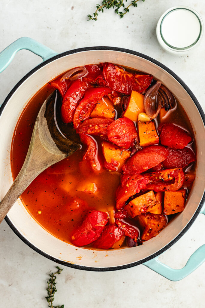 The roasted veggies and vegetable stock in a soup pot.