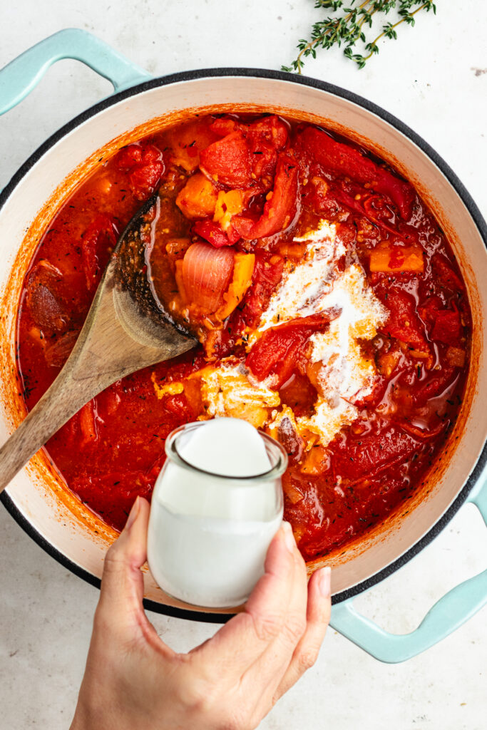 Adding the cream to the cooked soup.