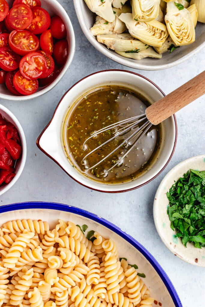 The dressing in a small bowl with a whisk.
