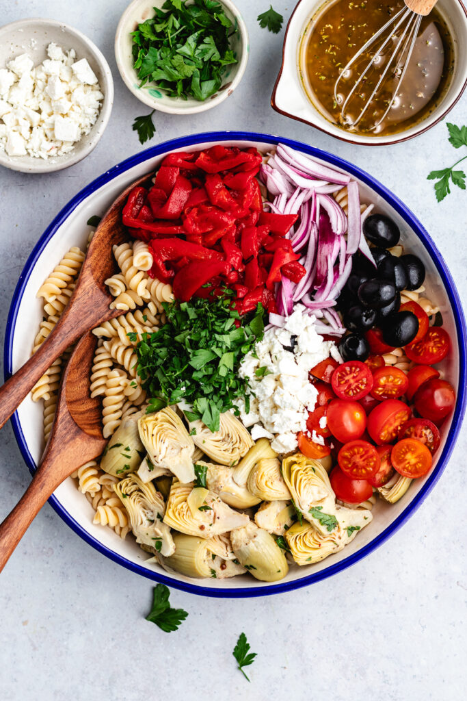 The vegetables, cheese and herbs added to the bowl with the pasta.