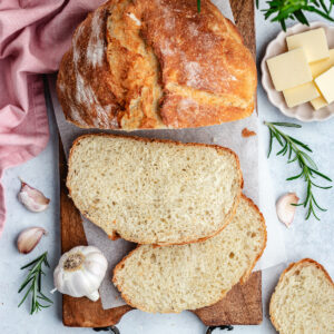 The bread cut into slices on a cutting board.