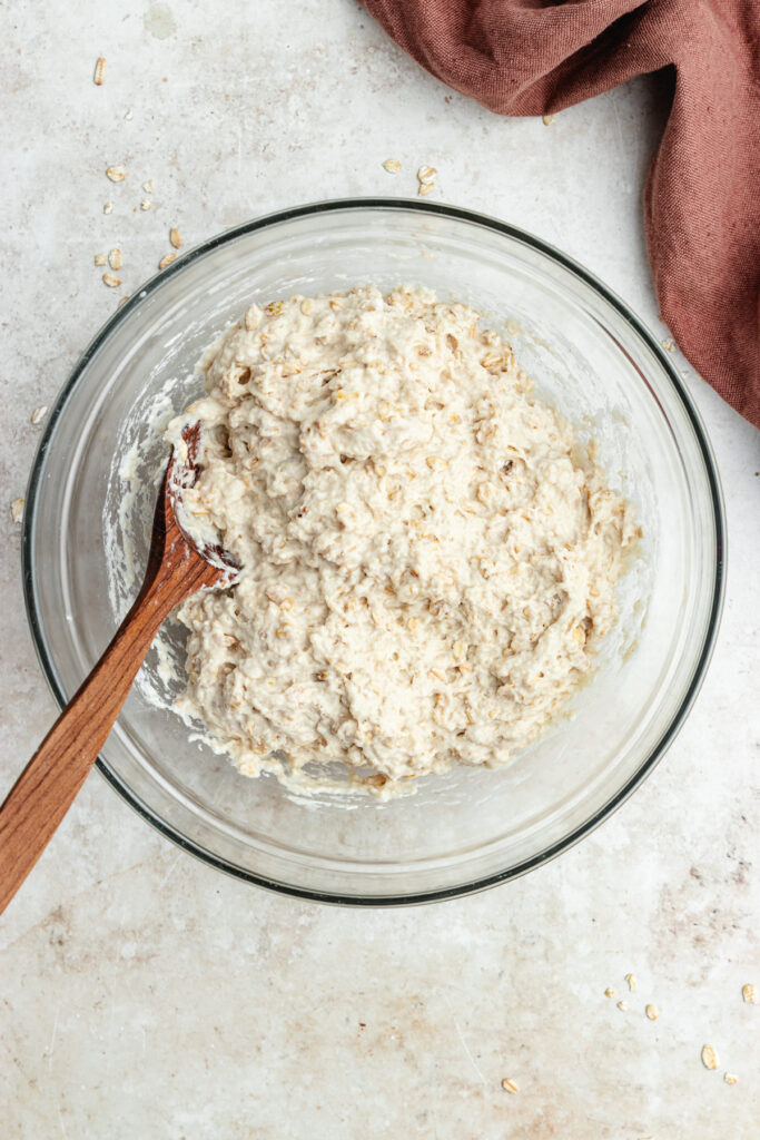 The dough in the bowl with a wooden spoon.
