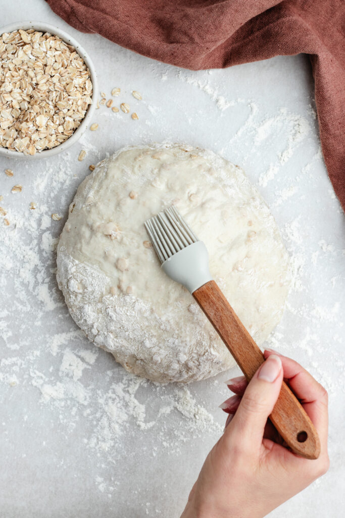 Brushing the bread with water.