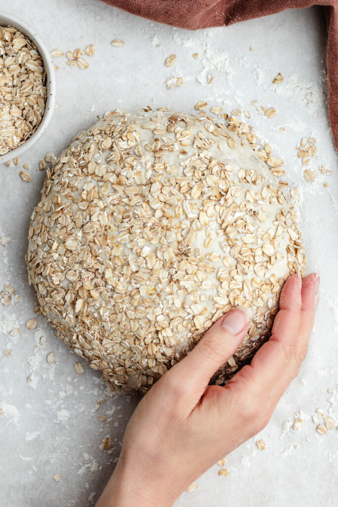 Topping the bread with rolled oats.