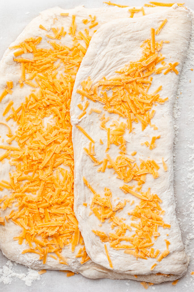 The dough folded once over covered with cheese.