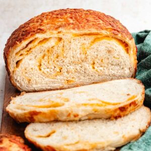 The bread cut into slices to show the inside with cheese swirls.