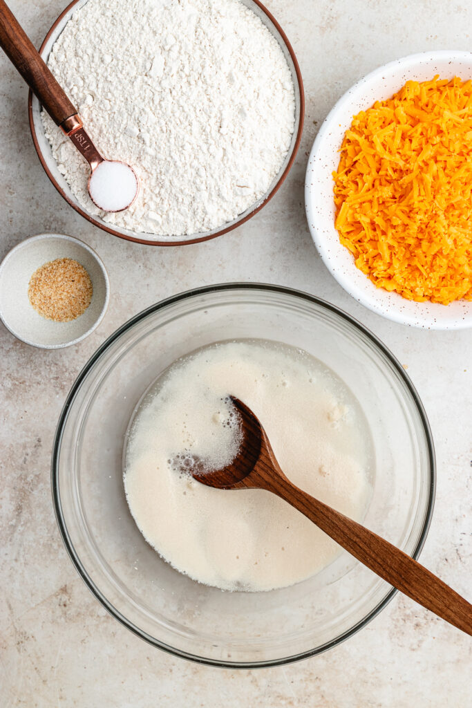 The yeast and water mixed in a bowl with a wooden spoon.