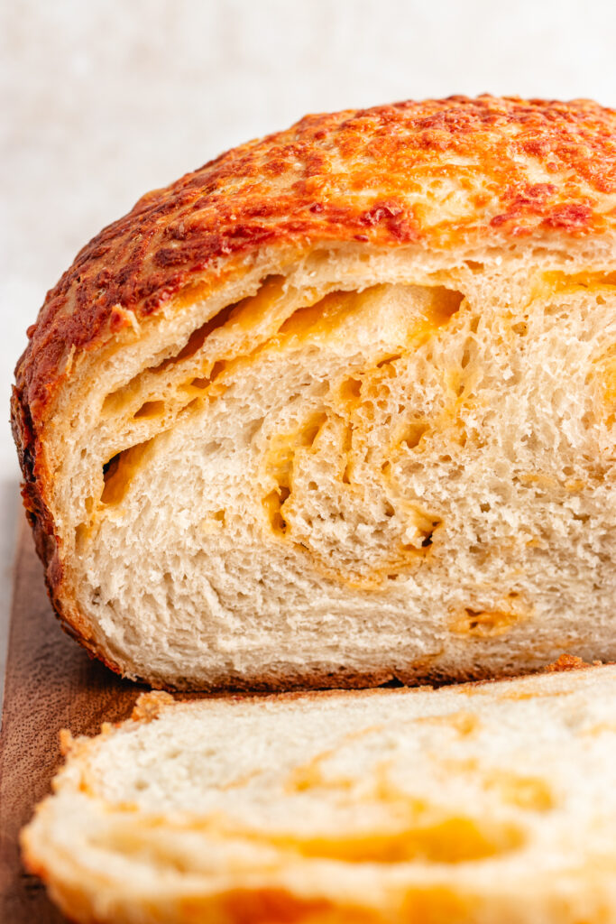 The bread cut into slices to show the inside with cheese swirls.