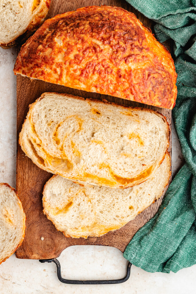 The bread on a cutting board, cut into slices.