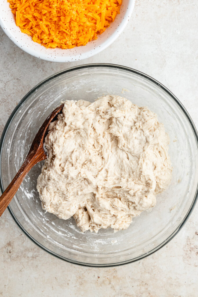 The dough with a wooden spoon in a bowl.