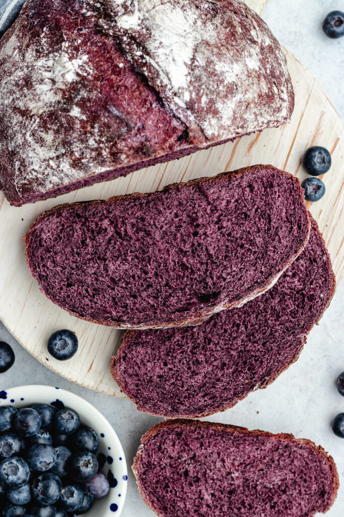 The bread on a cutting board, cut into slices.