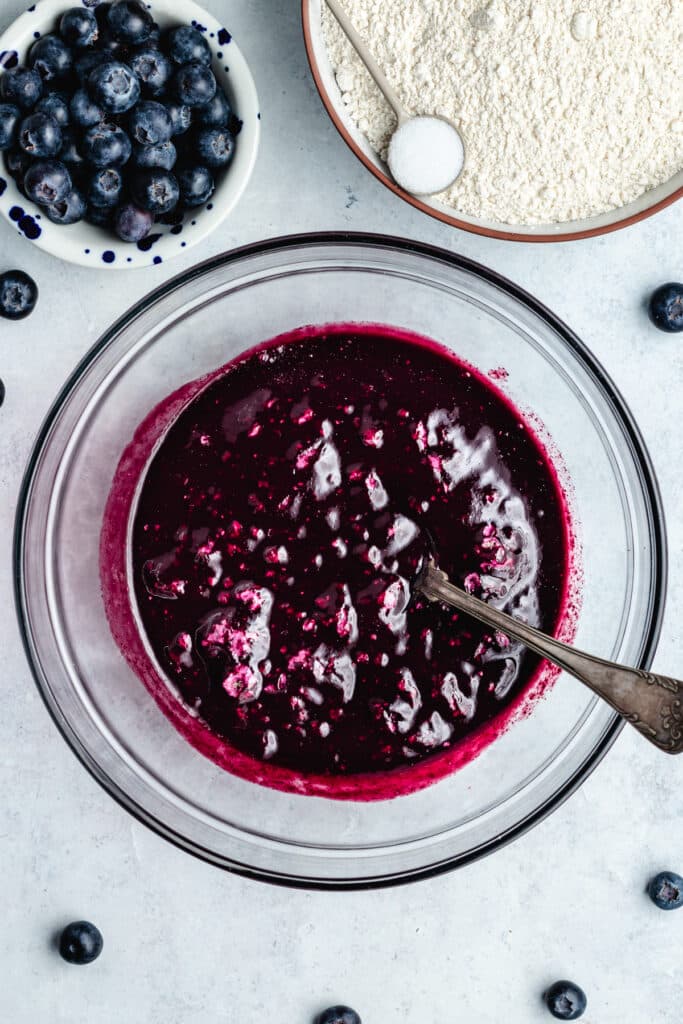 The blueberry purée in a mixing bowl with the sugar and yeast.