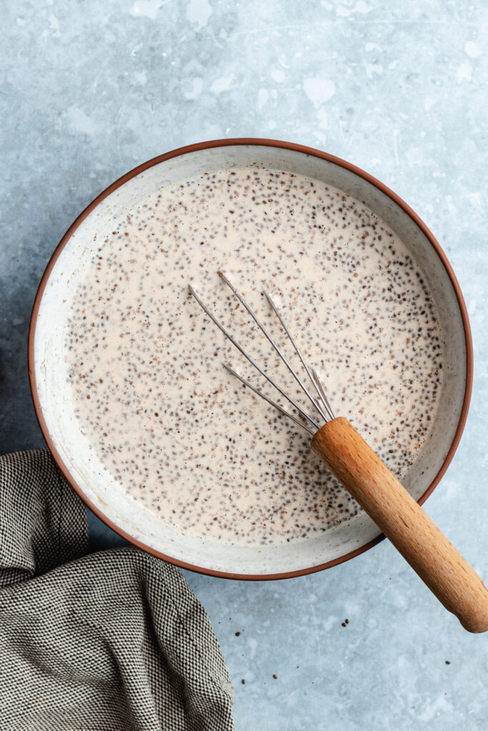 The chia pudding in the bowl with a whisk.