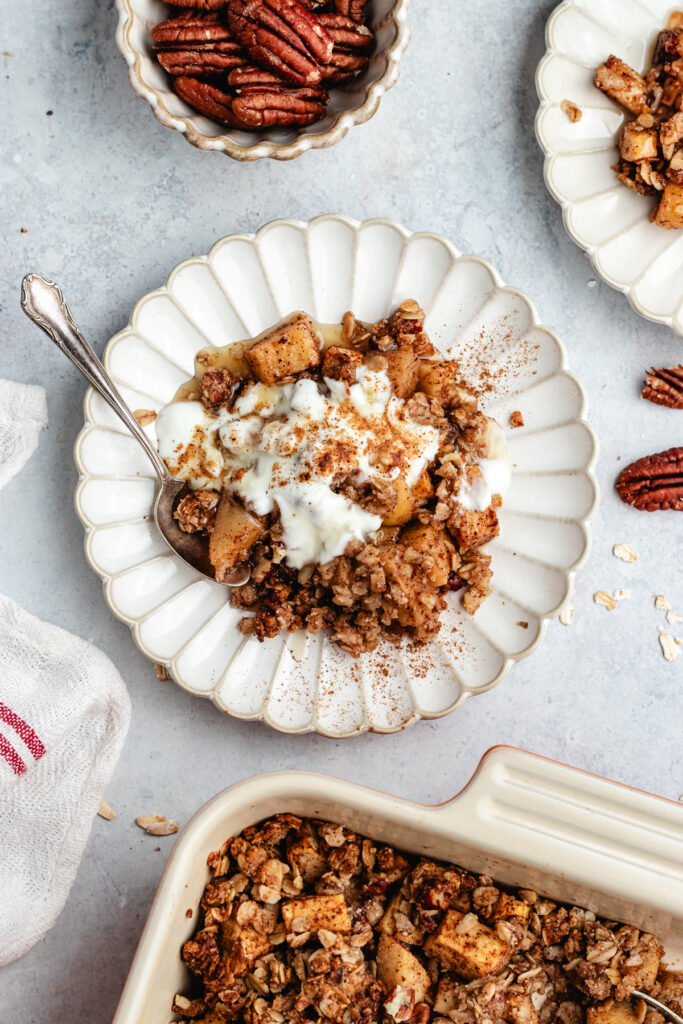 The crumble in the baking dish and 2 small plates with the crumble topped with some yoghurt.