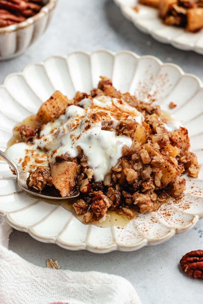 The crumble on a small plate topped with some yoghurt.