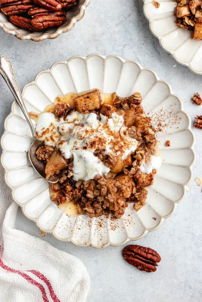The crumble on a small plate topped with some yoghurt.