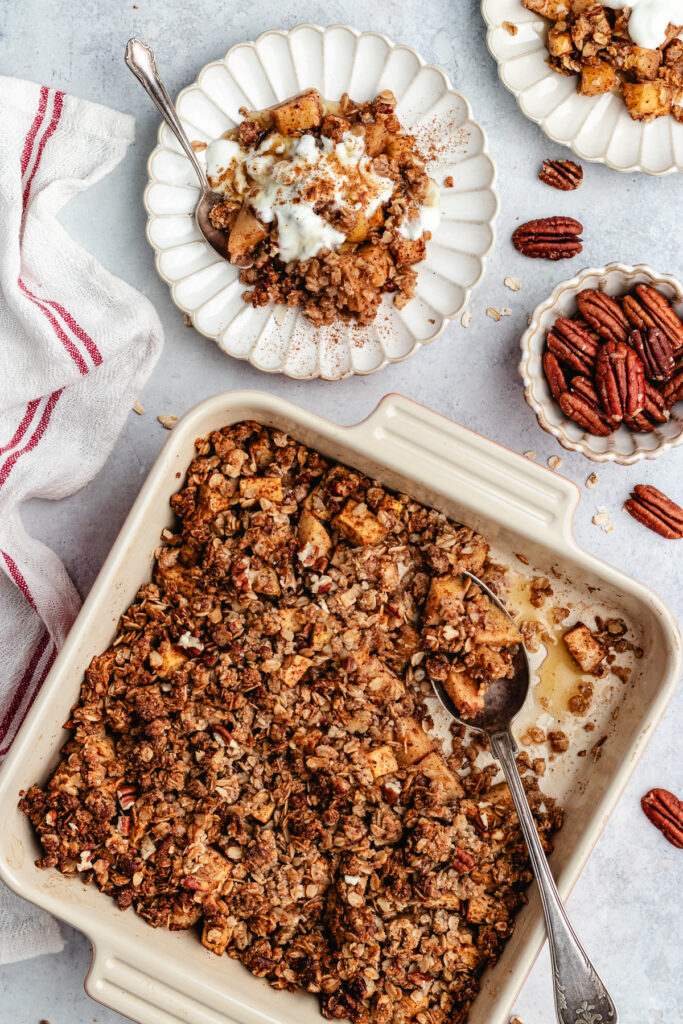 The crumble in the baking dish and 2 small plates with the crumble topped with some yoghurt.